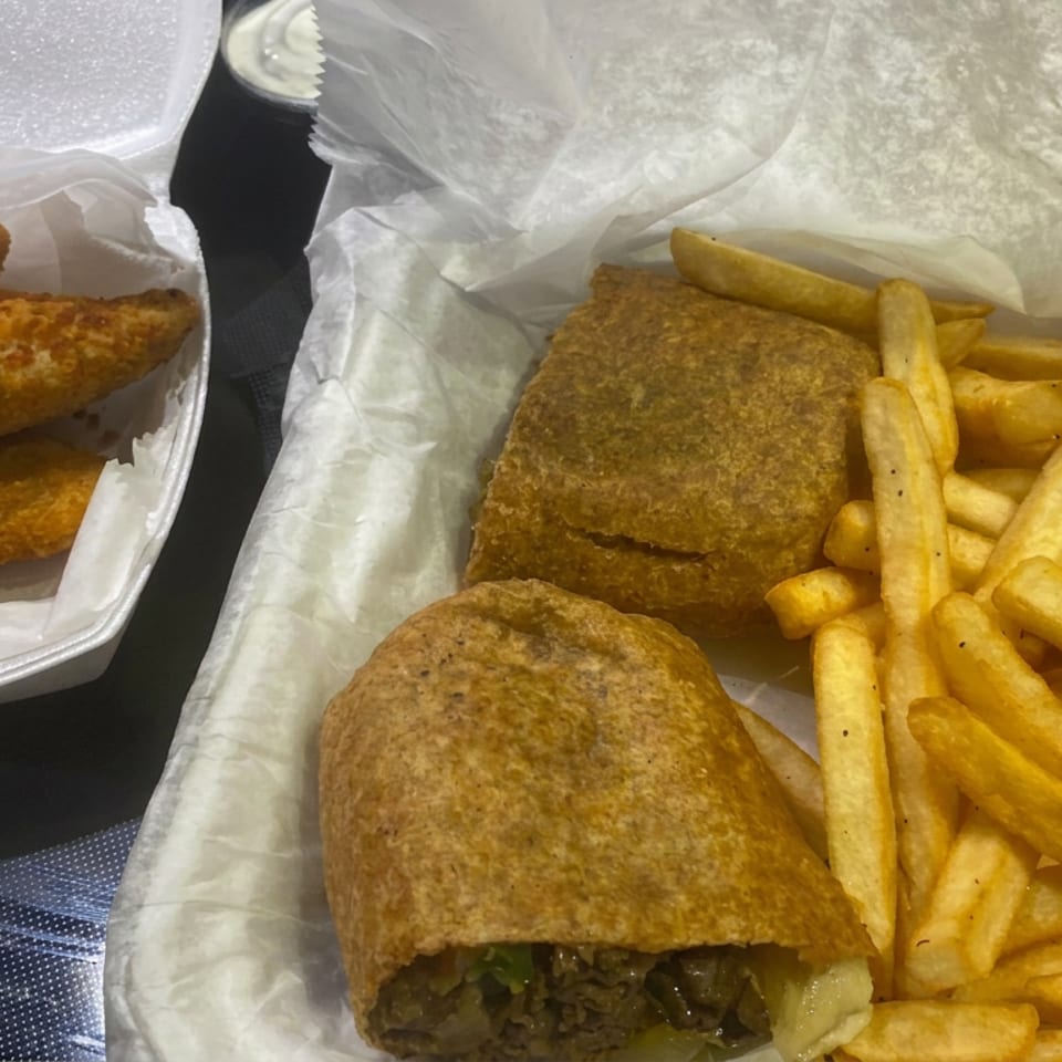 Takeout meal with two stuffed pastries, French fries, and a container of golden fried appetizers.